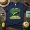 Navy blue t-shirt featuring the phrase "IT'S A JAMAICAN YUH NAH GUH UNDERSTAND" with a Jamaican flag map graphic
