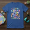 It's A Touch Of The 'Tism t-shirt design featuring colorful wavy text, a cute dragon, flowers, and puzzle pieces