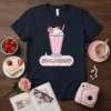 T-shirt design featuring the Japanese text "おいしい女の子" (Delicious Girl) above a kawaii strawberry milkshake graphic