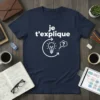 Navy blue t-shirt with white French text "je t'explique" and a graphic of a lightbulb in a circular flow, indicating