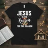 Jesus Is The Reason For The Season Christmas t-shirt with bold white text and a graphic of hands holding the