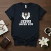 Jesus Loves You T-Shirt with hands holding a cross graphic and radiating light, in white and gold on navy fabric