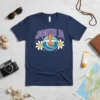 Navy blue t-shirt featuring "JOHN B POGUES FOR LIFE OBX" text with a surfboard and waves graphic, surrounded by daisies