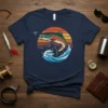 Jumping fish graphic with sunset and mountain background on a navy blue t-shirt, primary keyword Jumping Fish Sunset