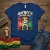 Juneteenth Freedom Rings t-shirt with a raised fist breaking chains and silhouetted figures celebrating under fireworks