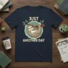 Just Another Day sloth hanging on a branch with coffee mug graphic on navy blue t-shirt