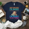 Just Because I'm Awake Doesn't Mean I'm Ready To Do Things quote with a sloth graphic on a navy t-shirt