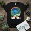 Black t-shirt featuring a blue frog sitting on a branch with rain falling, text reads "JUST FROG"