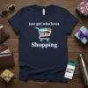 Navy t-shirt with white text "just girl who loves Shopping" and a graphic of a shopping cart filled with gift