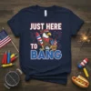 Just Here To Bang patriotic t-shirt design with a cool eagle holding fireworks and surrounded by July 4th graphics