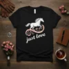 Black t-shirt with white "just love" text and a white horse jumping over a pink patterned swirl