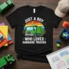 Just A Boy Who Loves Garbage Trucks text with a green cartoon garbage truck graphic on a black t-shirt