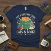 Just A Girl Who Loves Cats & Books quote on a navy t-shirt with a cat sleeping on an open