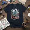 Just a girl who loves crafts text design on a navy t-shirt with colorful floral accents and crafting tools