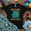 Black t-shirt with "JUST A GIRL WHO LOVES CROCHET" text and an armchair graphic made of teal yarn with a
