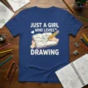 Just a girl who loves drawing t-shirt featuring white text and an illustration of hands drawing in a sketchbook