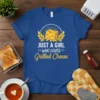 Blue t-shirt with "JUST A GIRL WHO LOVES Grilled Cheese" text and a smiling cheese graphic, surrounded by wheat stalks