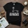 Just A Girl Who Loves Ostriches text design with a cartoon ostrich graphic on a black t-shirt