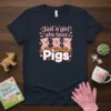Just a girl who loves Pigs text with three cute cartoon pigs playing in mud on a navy blue t-shirt