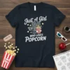 Just A Girl WHO LOVES POPCORN text with vintage movie camera and popcorn graphic on a navy t-shirt