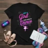 Black t-shirt with pink and blue text reading "JUST A Girl WHO LOVES TO Dance" and a glowing ballerina silhouette