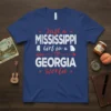 Just a Mississippi Girl in a Georgia World text design on a blue t-shirt, featuring state outlines and heart graphic