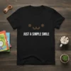 Black t-shirt with white text "JUST A SIMPLE SMILE" and a cute brown smiling face graphic