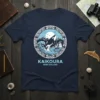 Kaikoura New Zealand t-shirt design featuring an orca whale jumping over a wave with mountains and sun in the background