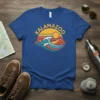 Kalamazoo text graphic with a retro sunset and ocean wave design on a blue t-shirt