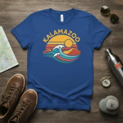Kalamazoo text graphic with a retro sunset and ocean wave design on a blue t-shirt