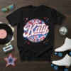 Black t-shirt with "Katy" in white and blue script over a colorful disco ball graphic, surrounded by pink and blue