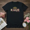 Black t-shirt with "KAUR A PRINCESS" text, featuring a floral pattern within "KAUR" and a golden crown graphic
