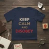 Keep Calm and Disobey text design on a navy blue t-shirt, featuring gold and red lettering with a protest fist
