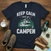 Keep Calm and Go Campen text with RV camper graphic, mountains, and trees on a navy t-shirt