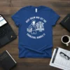 Keep Calm And Let The Paralegal Handle It quote on a royal blue t-shirt with legal scales and stacks of