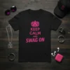 Black t-shirt with "KEEP CALM AND SWAG ON" text in pink, featuring a pink crown graphic above the text