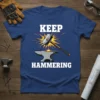 Keep Hammering t-shirt design with a hammer striking an anvil, symbolizing blacksmithing and metalwork