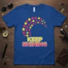 Keep Shining t-shirt with a vibrant yellow and pink starburst design and bold typography