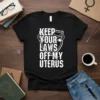 Keep Your Laws Off My Uterus slogan with a shield and uterus graphic on a black t-shirt