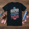 Black t-shirt with "Keeper of the Gender Touchdowns or Tutus" text in white, blue, and pink, featuring football helmet and