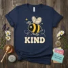 KIND Bee T-Shirt with a cute bumblebee graphic and "KIND" text, surrounded by stars and swirls