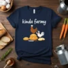 Navy t-shirt with white text "kinda farmy" above a brown chicken and a white chicken chef on a stack of