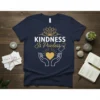 Kindness Is Priceless quote on a navy blue t-shirt with golden heart and lotus graphic
