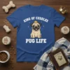 King Of Cuddles Pug Life text with a cute pug wearing a crown on a blue t-shirt