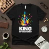 King Of The Board text with a colorful, abstract chess king graphic on a black t-shirt