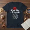 Kiss Me, I'm Amish! quote on a navy t-shirt with a red lip graphic and a circular farm illustration