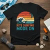 Kite Surfing Mode On text with retro sunset, wave, and kiteboarder graphic on black t-shirt