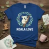 Koala Love t-shirt design with a mother and baby koala on a branch within a floral wreath