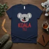 Cute cartoon koala with tongue out and text "KOALA TILI" in red on a navy blue t-shirt