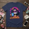 La Chismosa sugar skull graphic tee with a woman drinking coffee and wearing a flower crown, text "LA CHISMOSA" below